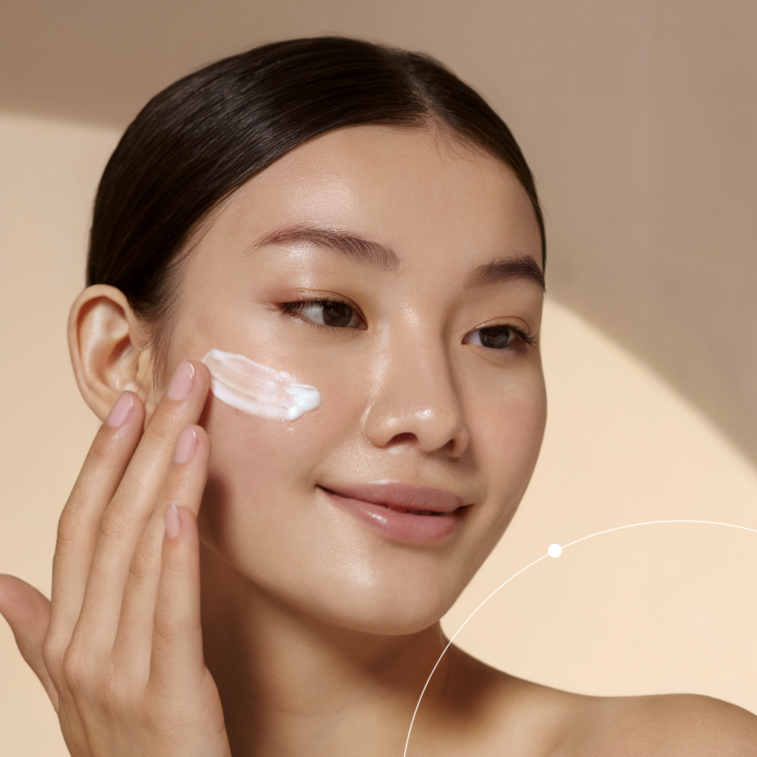Woman applying cream to her face with a beige background